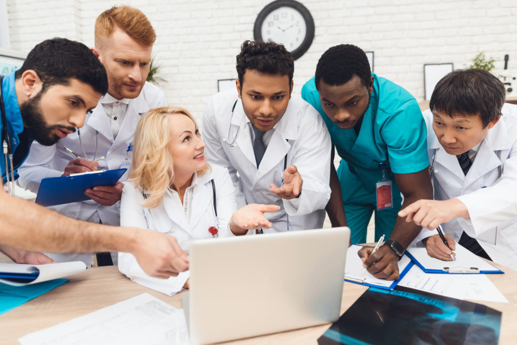 Hospital Multinational Doctors Looking On Laptop.