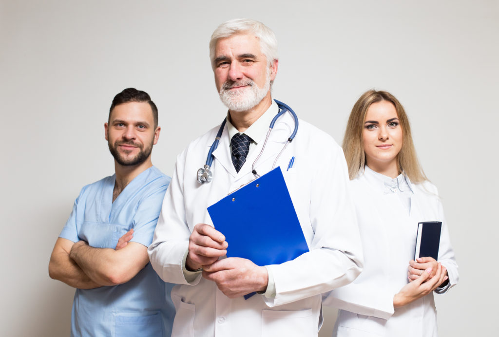 Physicians standing next to each other smiling.