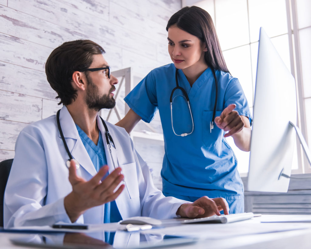 Doctors are using a computer and discussing.