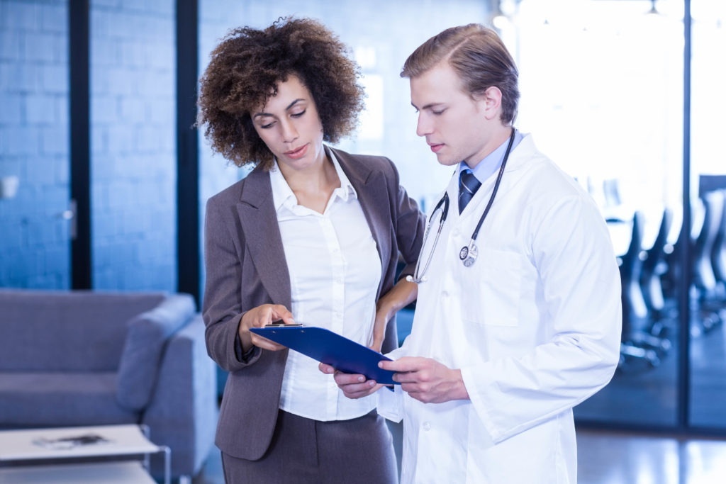 Doctor and colleague looking at medical report and having a discussion