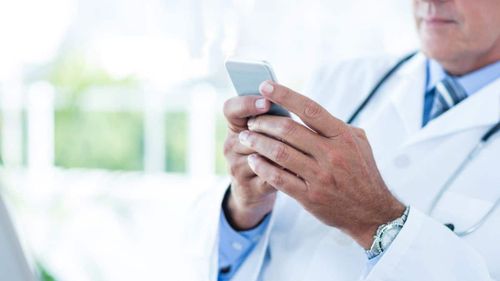 Doctor-using-mobile-phone-to-text
