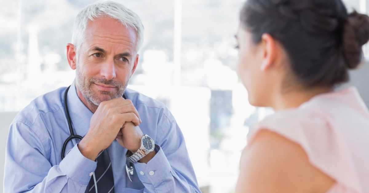 serious doctor listening to patient